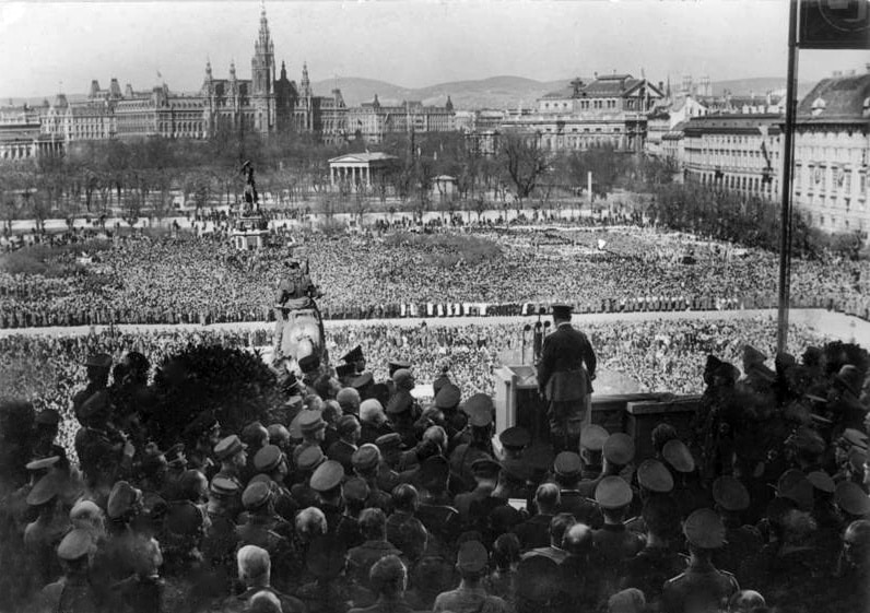 März 1938, sprach Adolf Hitler zum ersten male vonder Rampe der Winer Hofburg zu seinem Volk und zur Welt. Dankbar konnte er die Erfüllung dieser grossen, ihm vom Schicksal auferlegten Aufgabe als vollzogen vor der Geschichte melden.
