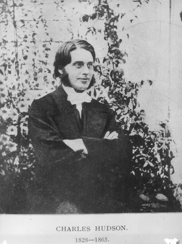 A vintage seated portrait of Reverend Charles Hudson, featuring mutton chop sideburns and a suit, with text "CHARLES HUDSON 1828-1865" below.