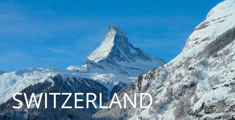 A majestic view of the snow-covered Matterhorn peak in Zermatt against a clear blue sky, with the word "SWITZERLAND" overlaid in large white capital letters across the bottom.