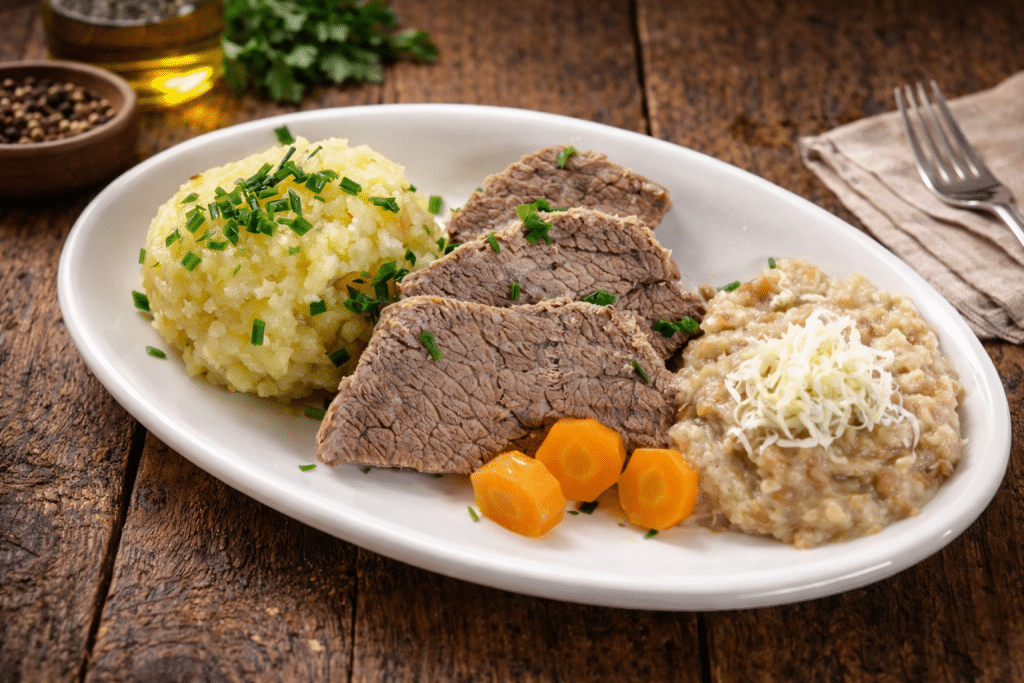 Sliced boiled beef (Tafelspitz) served with root vegetables, chive sauce, and apple-horseradish
